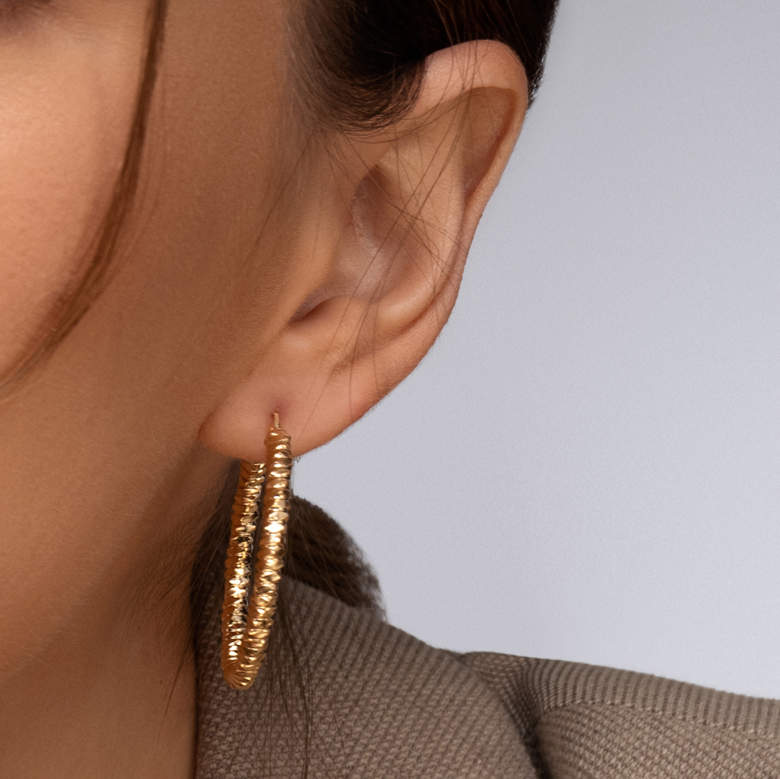 עגילי זהב חישוקים בגימור מחוספס בקוטר 3.6 ס"מ.