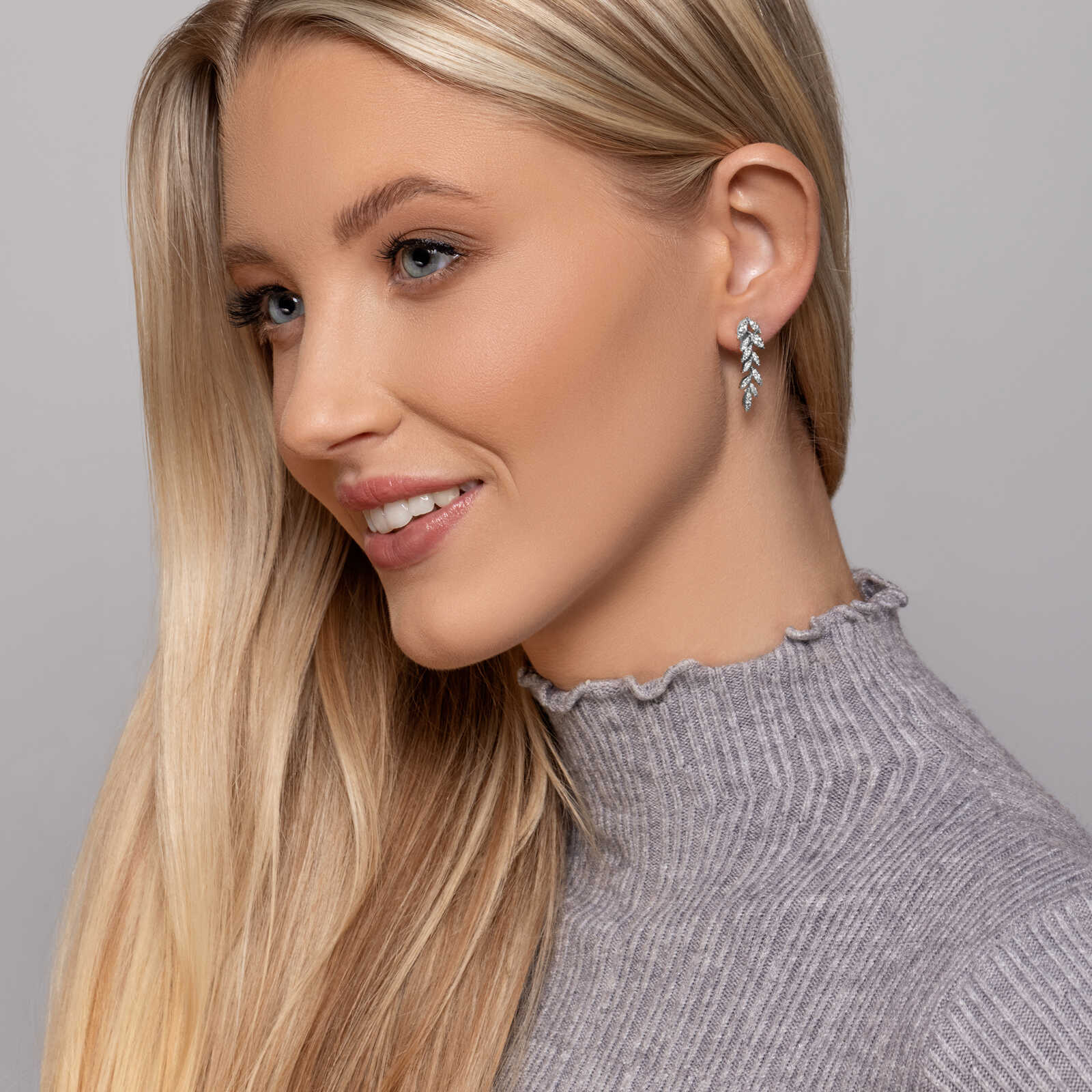 עגילי זהב המעוצבים כעלים המשובצים יהלומים