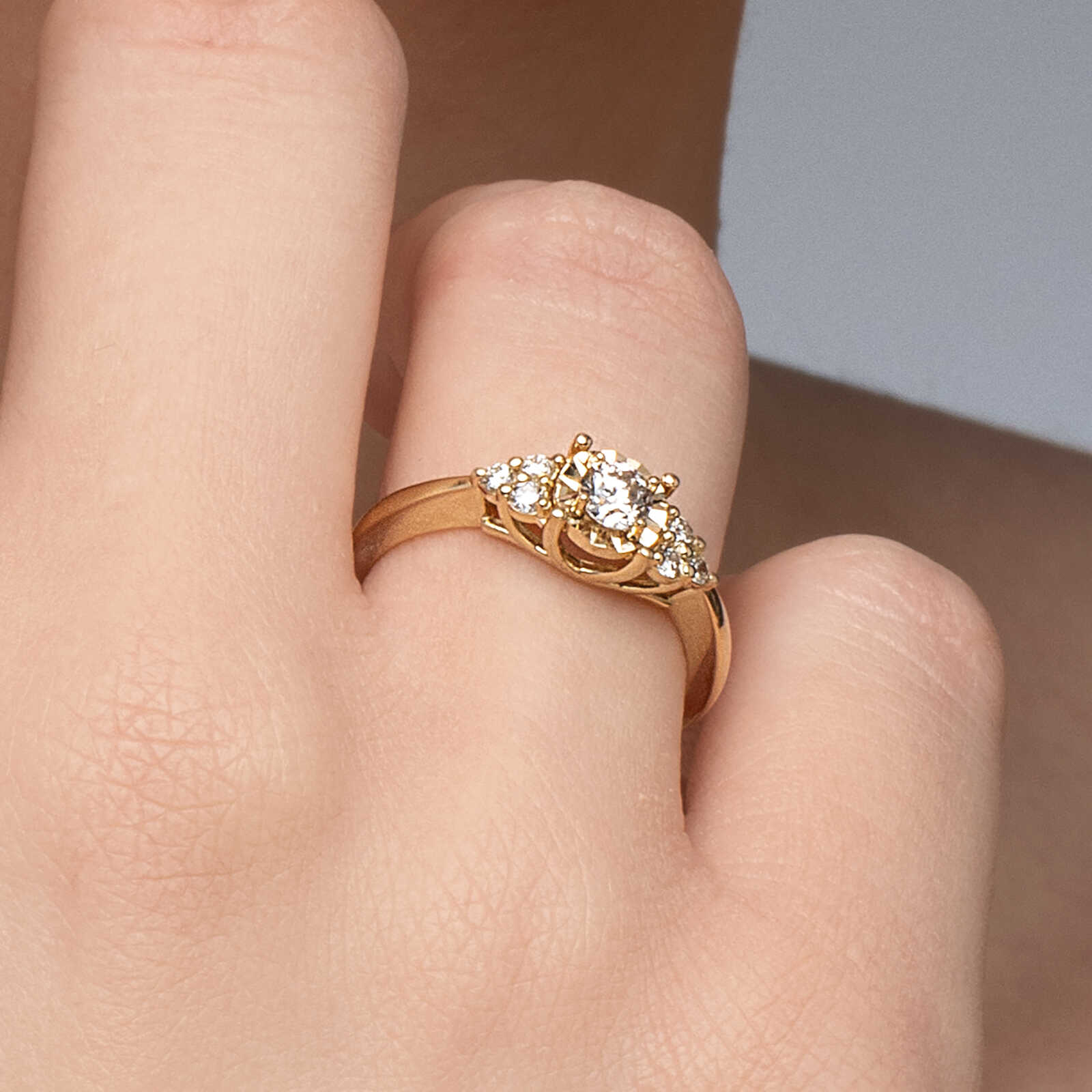 טבעת זהב משובצת יהלום מרכזי מוקף זהב בעיבוד לייזר